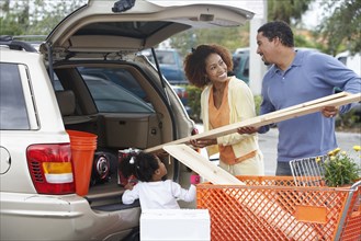 Black family loading car at home improvement store