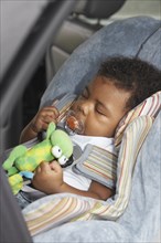Black baby sleeping in car seat