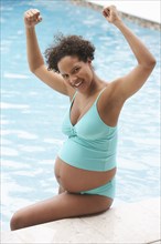 Pregnant woman cheering in swimming pool