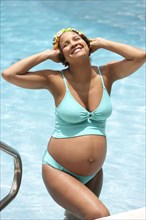 Pregnant woman smiling in swimming pool