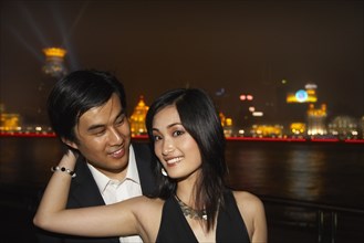 Couple by city skyline lit up at night