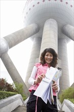 Chinese woman with map under Oriental Pearl Tower