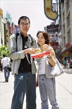 Chinese couple eating on city street