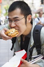Chinese man eating on city street