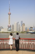 Chinese couple looking at city skyline