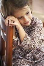 Girl sitting in wooden chair