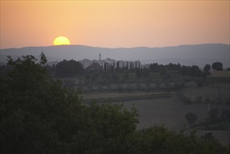 Sun setting over rural landscape