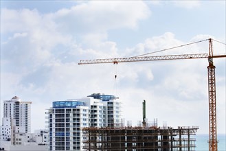 Crane extending over urban construction site