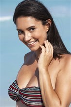 Hispanic woman smiling on beach