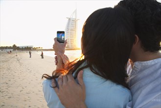 Couple taking pictures together on beach