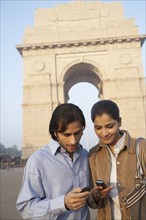 Indian couple using cell phone by India Gate