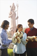 Indian family receiving flowers by monument
