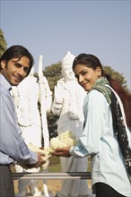 Indian couple offering flowers to shrine