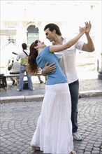 Caucasian couple dancing on city street