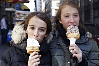 Girls eating ice cream on city street