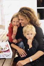 Caucasian mother and children eating outdoors