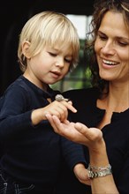 Caucasian mother and son examining snail