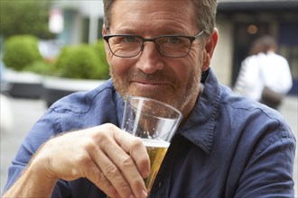 Caucasian man drinking beer outdoors