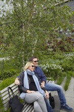 Caucasian couple relaxing on bench in park