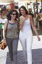 Caucasian mother and daughter walking in market