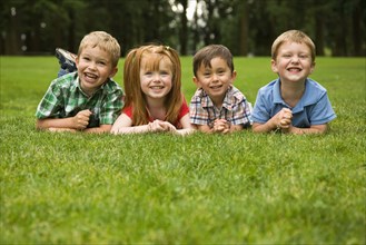 Children laying in grass in park