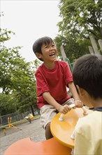 Laughing Asian boy playing on playground