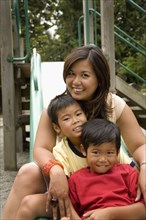 Asian family sitting together on slide