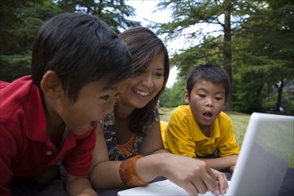 Asian mother showing sons laptop