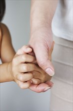 Chinese woman holding daughter's hand