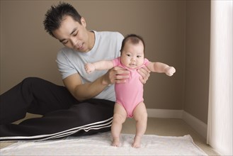 Chinese father helping daughter to learn to walk