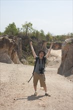 Chinese tourist laughing with arms raised