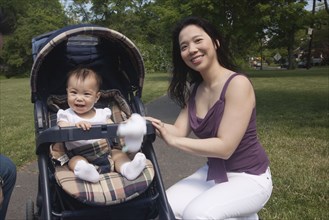 Chinese mother and baby in stroller at park