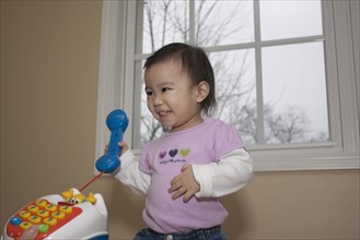 Chinese baby girl playing with toy telephone