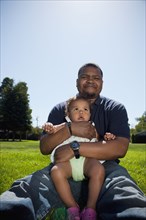 Father holding daughter in park