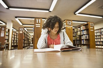 Mixed race girl studying in library