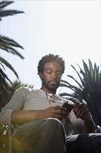 Black man listening to mp3 player outdoors