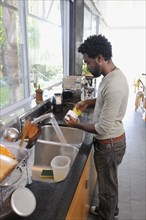 Black man washing dishes
