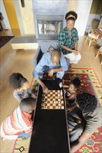 Black family watching chess game