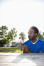 African American man text messaging outdoors
