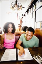 Smiling couple reading menu in diner