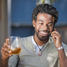 Black man talking on cell phone and drinking