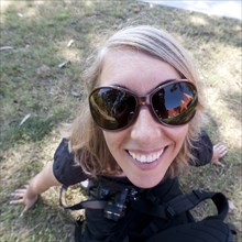Caucasian woman in sunglasses holding camera