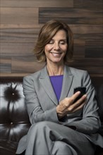 Caucasian businesswoman using cell phone in office