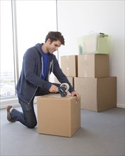 Caucasian man packing cardboard boxes