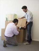 Hispanic men packing cardboard boxes
