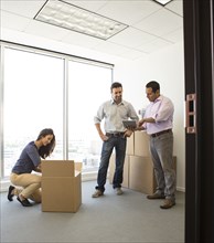 Business people unpacking in new office