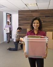 Businesswoman carrying boxes in office