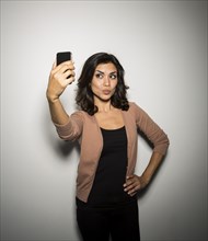 Mixed race businesswoman taking cell phone picture