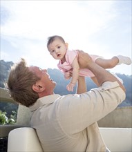 Father holding baby girl on sofa