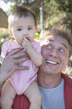 Father playing with baby girl outdoors